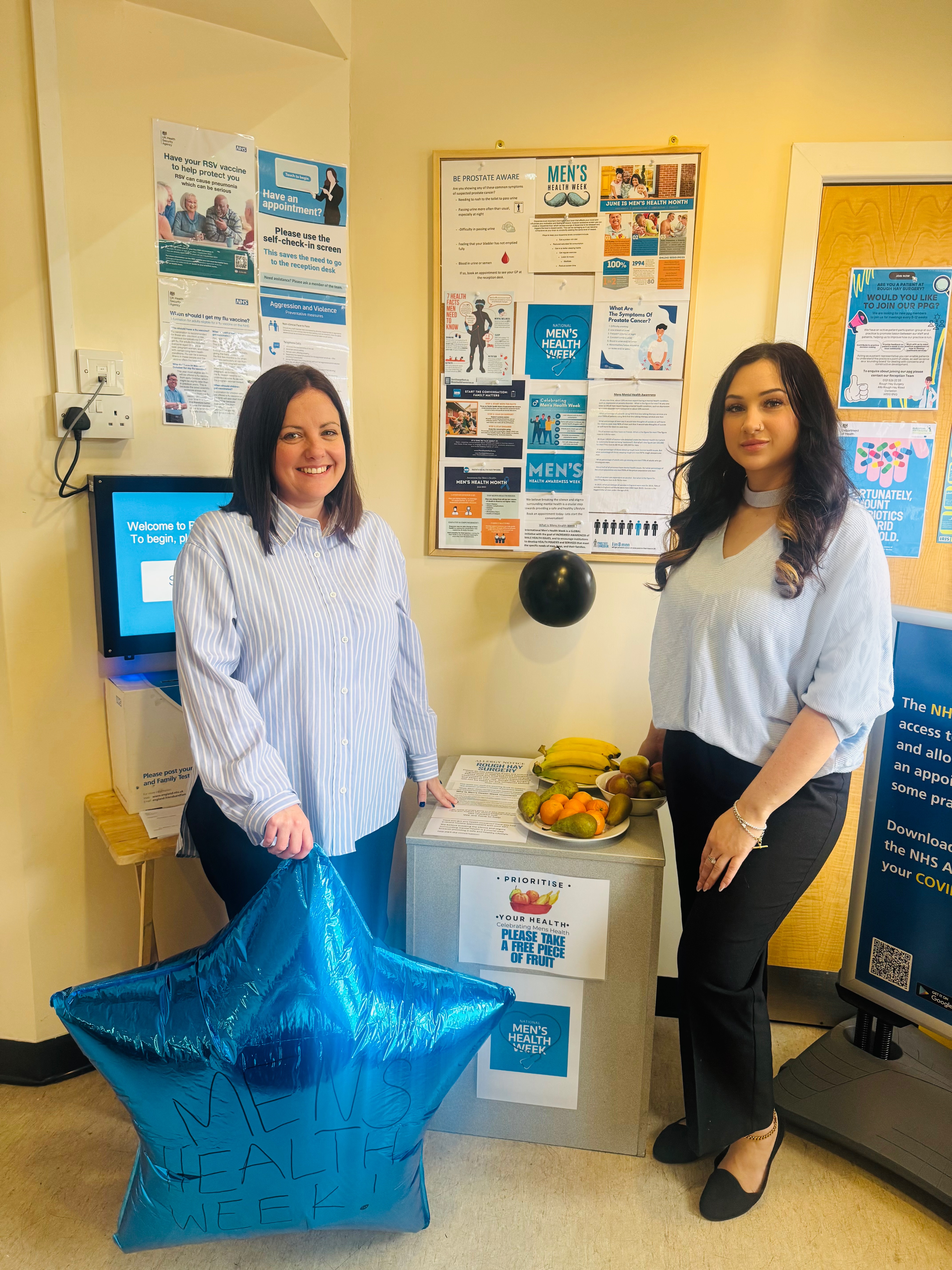 Two members of the practice stood with the mens health awareness information